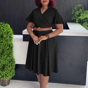 Detail of V-neck casual black dress with brown belt and ruffled sleeves in indoor setting