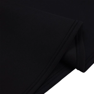 Détail de couture à double aiguille sur l'ourlet d'une robe de soirée noire en maille fine