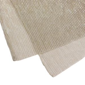 Detail of metallic pleated champagne fabric with shimmering gold texture and overlock edges