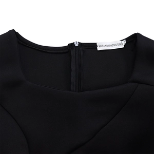 Detail of the elegant black dress showing neckline, M-size tag, and invisible back zipper