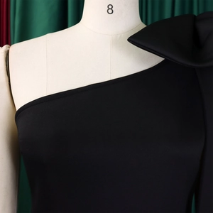 Close-up detail of the elegant one-shoulder neckline on a black sleek formal dress