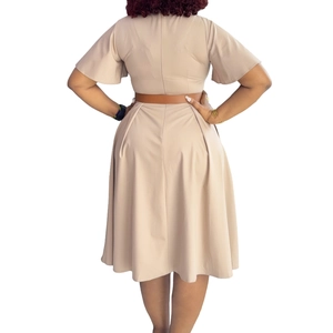 Back view of a beige A-line dress with ruffle sleeves and a thin brown waist belt