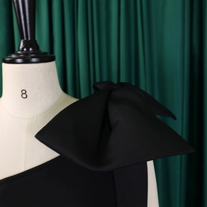 Detailed view of the structured oversized bow on the shoulder of this black gown