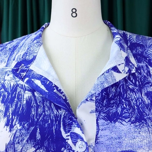 Détail d'imprimé floral tropical sur une robe à manches courtes avec col et bouton