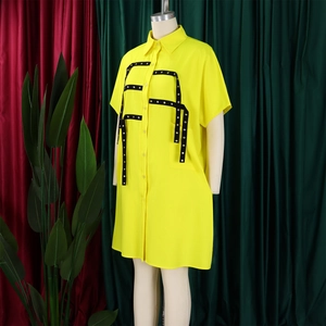 Detail of yellow short sleeve shirt dress featuring asymmetric black eyelet straps