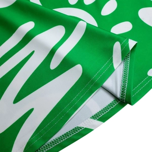 Detailed close-up showing precision stitching and hemline on green African print fabric
