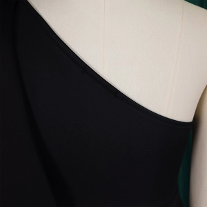 Detail view of the black one-shoulder neckline and stitched edge on an evening gown