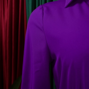 Close-up of deep purple satin dress featuring a sharp V-neck collar and pleated shoulders