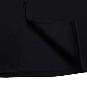 Detail of double-needle stitching on the hem of a black knit ruffled bodycon dress