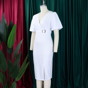 Detail of white V-neck dress featuring puff sleeves and an elegant slit hemline