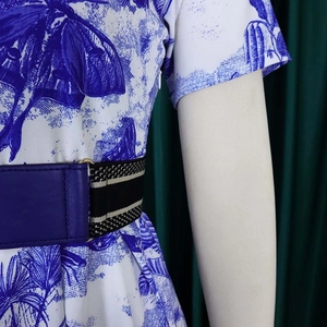 Détail d'une robe imprimée Toile de Jouy bleue avec une large ceinture en cuir synthétique