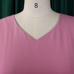 Detailed close-up of the V-neckline on a pink woven A-line dress for women