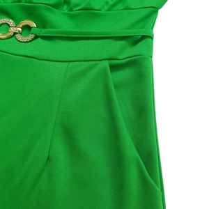 Detailed macro view of vibrant green high-waist jumpsuit with gold rhinestone buckle belt