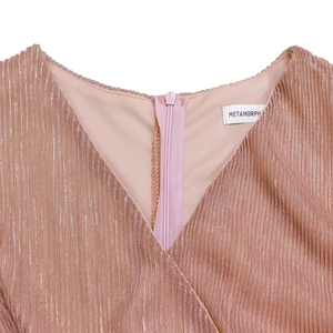 Detail view of metallic rose gold pleated fabric and V-neckline with a matching zipper