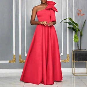 Detail of elegant red one-shoulder evening gown featuring a large dramatic bow on shoulder