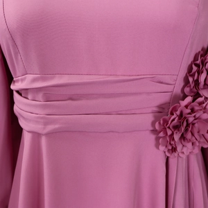 Detailed close-up of rose pink ruched waist design with handmade floral decoration