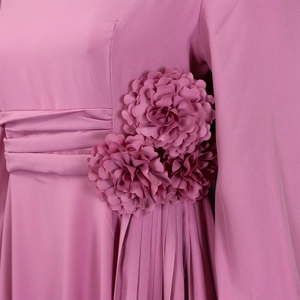 Close-up of pink dress with 3D fabric flowers, waist pleats and vertical pleated skirt
