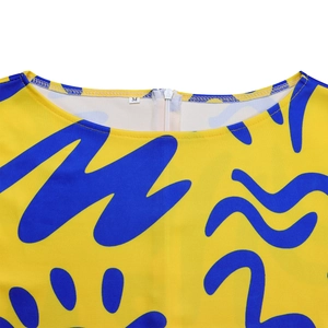 Detail view of round neckline and back zipper on yellow African print dress, size M