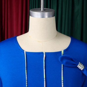 Detailed close-up of a blue dress featuring a square neckline and ribbon bow ornament