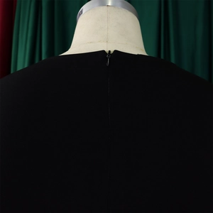 Détail de la fermeture éclair invisible au dos de cette robe noire élégante à manches courtes