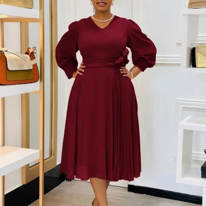 Detail of burgundy V-neck dress with floral waist accent and elegant pleated skirt finish