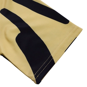 Gros plan du revers à double couture sur tissu jaune avec rayures noires géométriques