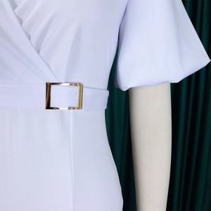 Close-up of V-neckline and white bubble sleeves with a gold buckle waist belt