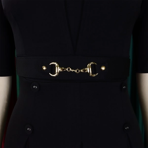 Détail d'une robe noire élégante avec une large ceinture et une boucle mors dorée