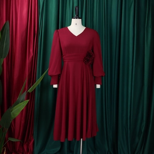 Detail of burgundy V-neck dress with long lantern sleeves and floral waist decoration