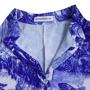 Détail du col à imprimé floral bleu et blanc avec boutons blancs et étiquette de marque