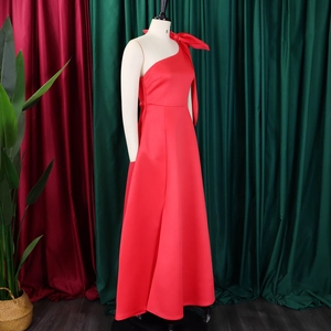 Elegant red one-shoulder evening gown with large bow detail and flared satin skirt