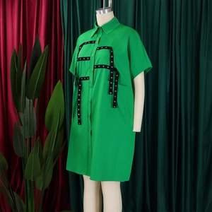 Detail of bright green shirt dress showing metal eyelets and black ribbon lattice pattern