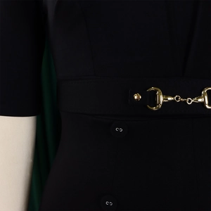 Détail de la taille d'une robe noire élégante avec boucle mors dorée et boutons