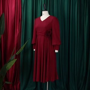 Detail of wine red V-neck dress with handcrafted 3D flower waist and pleated skirt side