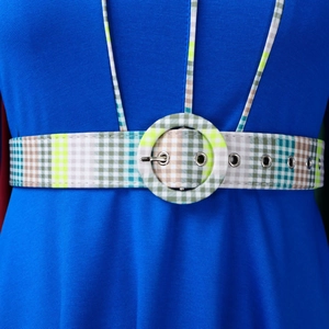 Detailed view of royal blue dress waist featuring checkered belt with a round fabric buckle