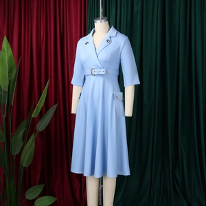 Détail d'une robe trapèze bleu clair avec col tailleur, ceinture et boucle en métal rond