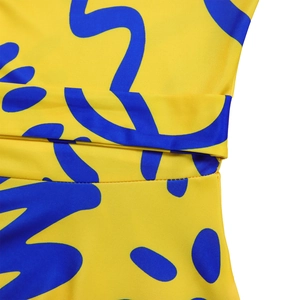 Macro shot of bright yellow fabric with blue abstract print and detailed sewing craftsmanship