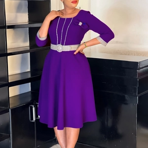 Detail of purple dress featuring round neck, three-quarter sleeves and checkered belt buckle