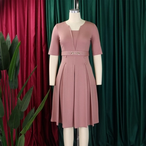 Détail d'une élégante robe midi rose poudré avec jupe plissée et ceinture à boucle