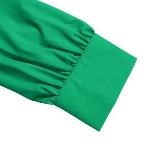 Detail of smocked cuffs and stitching on emerald green long sleeve V-neck pleated dress