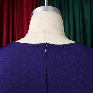 Dettaglio della cerniera invisibile su un abito viola a maniche corte strutturato