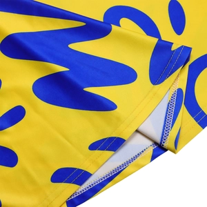 Detail of yellow and blue African print fabric showing breathable mesh texture and stitching