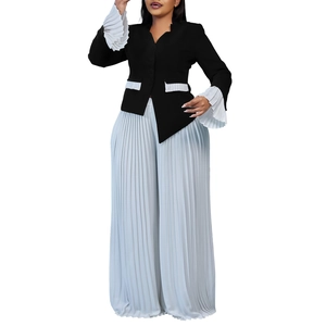 Detail of black blazer with white pleated cuffs and blue wide-leg pleated trousers set
