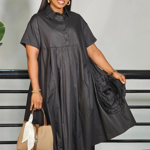 Detail of black short sleeve A-line shirt dress with 3D flower accent and button front