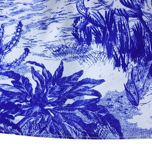 Gros plan sur tissu blanc avec imprimé floral bleu et détails de texture fins