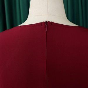 Detail view of the seamless invisible back zipper on a solid dark red elegant A-line dress