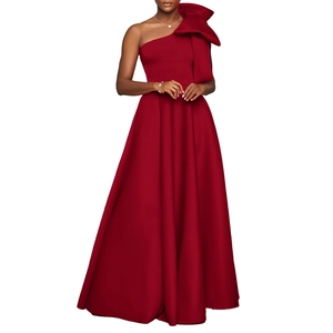 Detailed view of the large sculptural shoulder bow on this elegant dark red evening gown