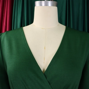 Detailed view of dark green V-neck wrap dress with textured horizontal ribbed fabric
