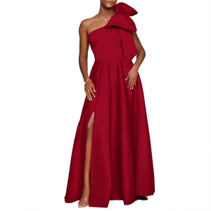 Detail of elegant one-shoulder evening gown featuring a large bow and high slit