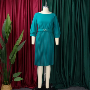Dettaglio dell'elegante abito a pieghe verde petrolio con scollo rotondo e cintura in vita